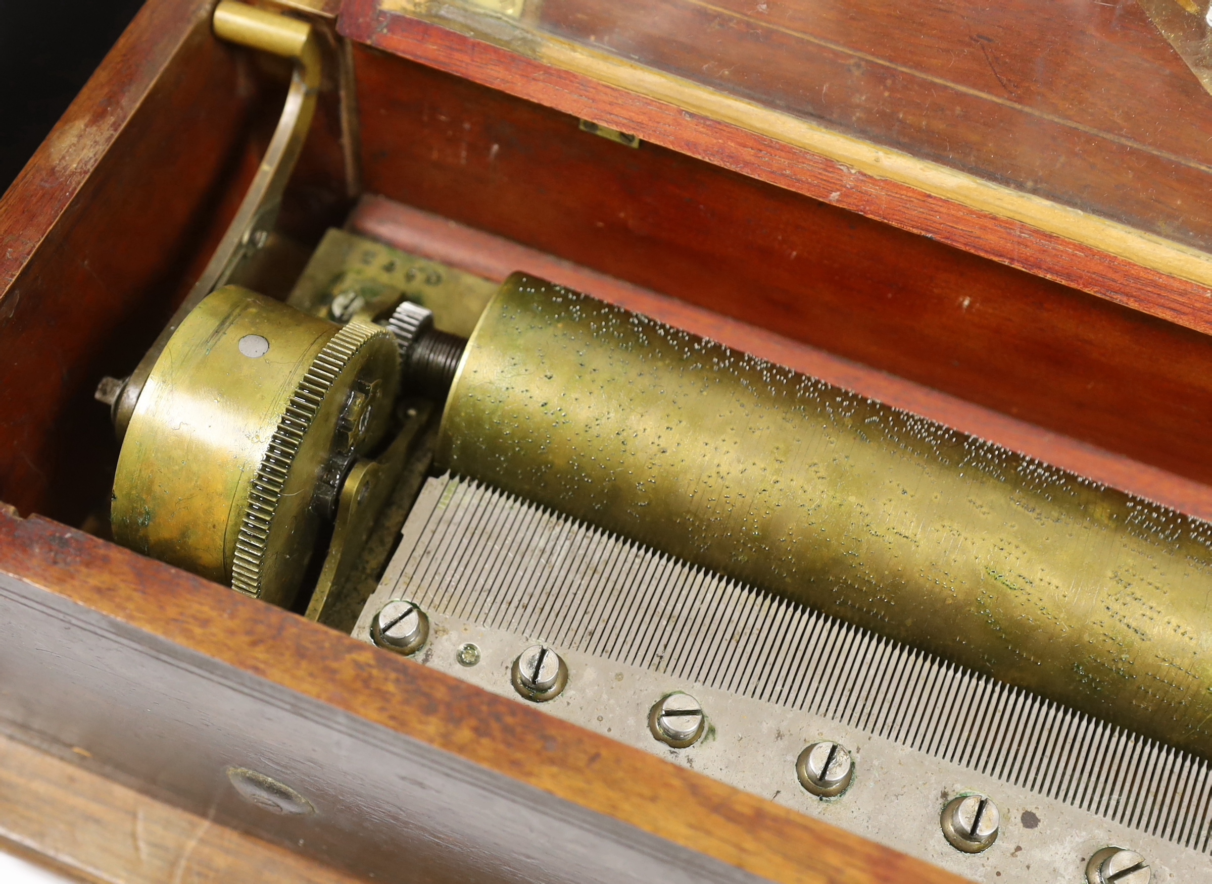 A late 19th century Swiss ‘forte piano’ cylinder musical box, in an inlaid mahogany case, playing four airs on two hundred and nineteen teeth, barrel 39cm wide, case; 57cm wide, 17cm deep, 13cm high, on a later separate